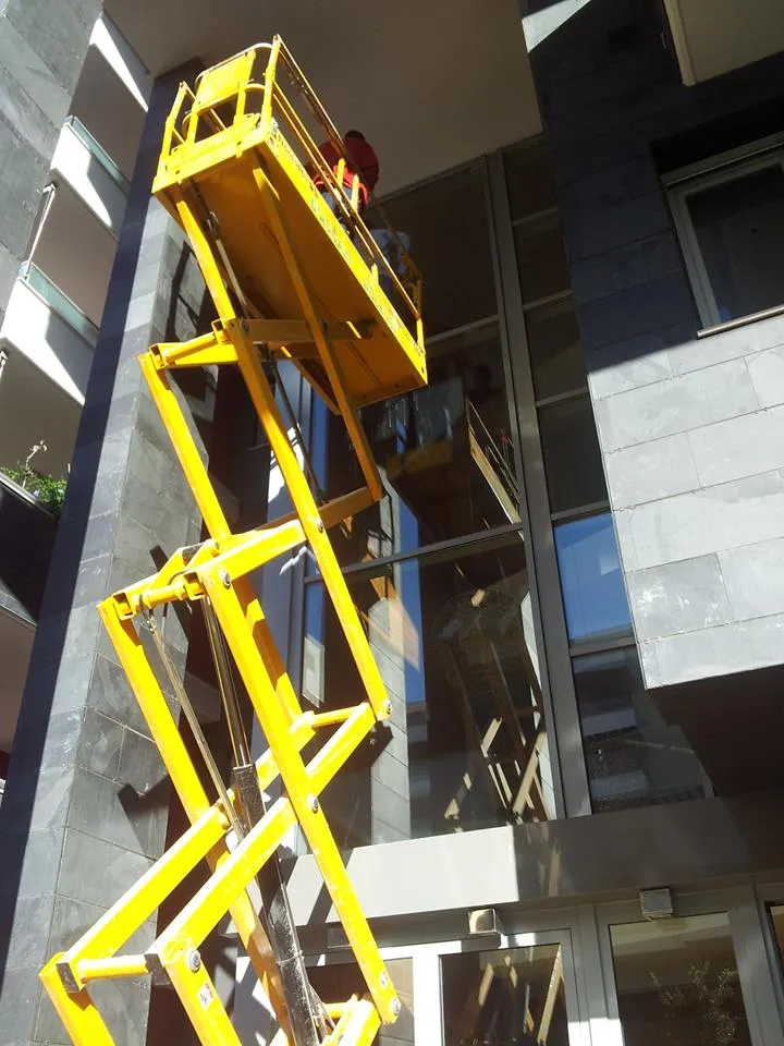 Lavaggio vetri in altezza in un condominio sito in Pescara con ausilio di piattaforma a pantografo.